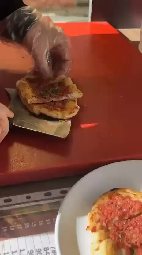 Fırından çıkmış güveç pidesi dilimlenip tabağa alınıyor
