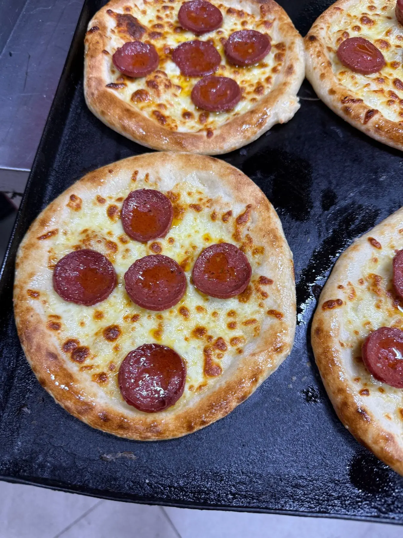 Fırın tepsisinde sucuklu, kaşarlı mini pizzalar