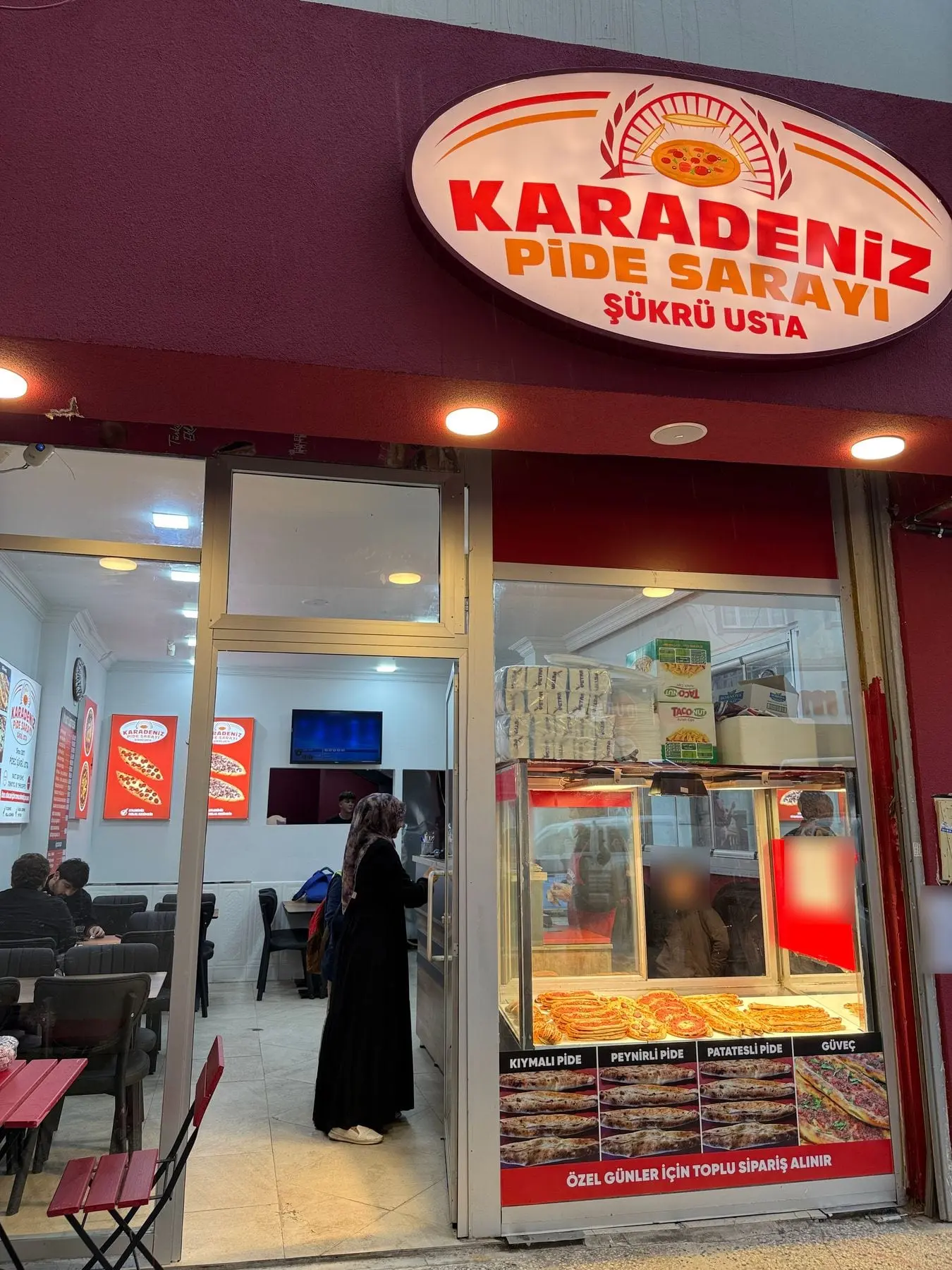 Karadeniz Pide Sarayı’nın akşamüstü ışıkları yanmış tabelası ve vitrini