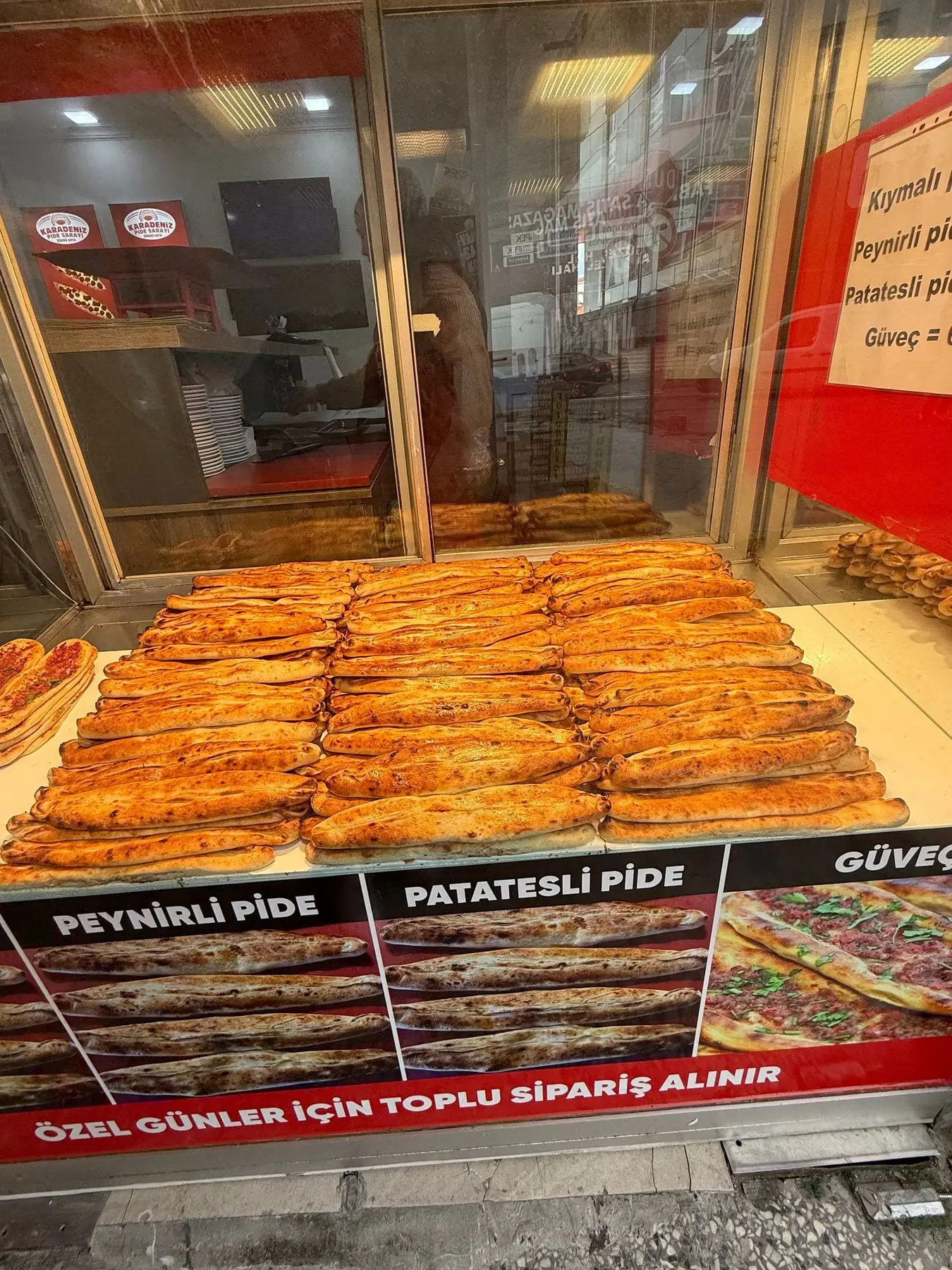 Vitrinde üst üste dizilmiş peynirli ve patatesli pideler