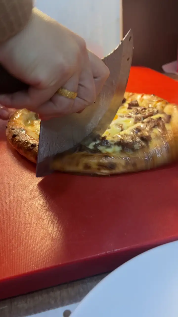Yuvarlak Trabzon yağlısı pidesi eğri bıçakla dilimleniyor